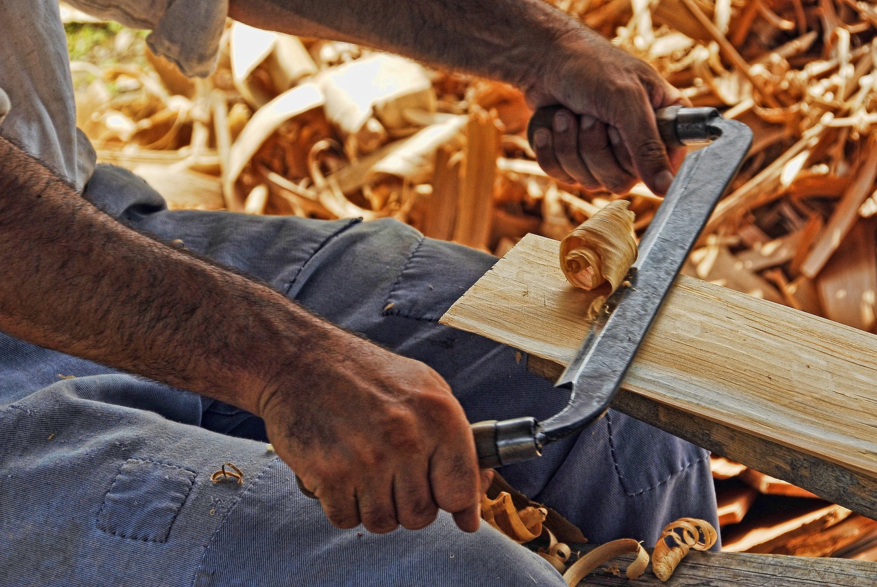 Carpenter's hands shaping a wood joint with a hand plane
