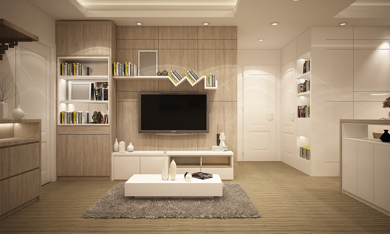A clean, light-wood living room with built-in shelving and cabinetry