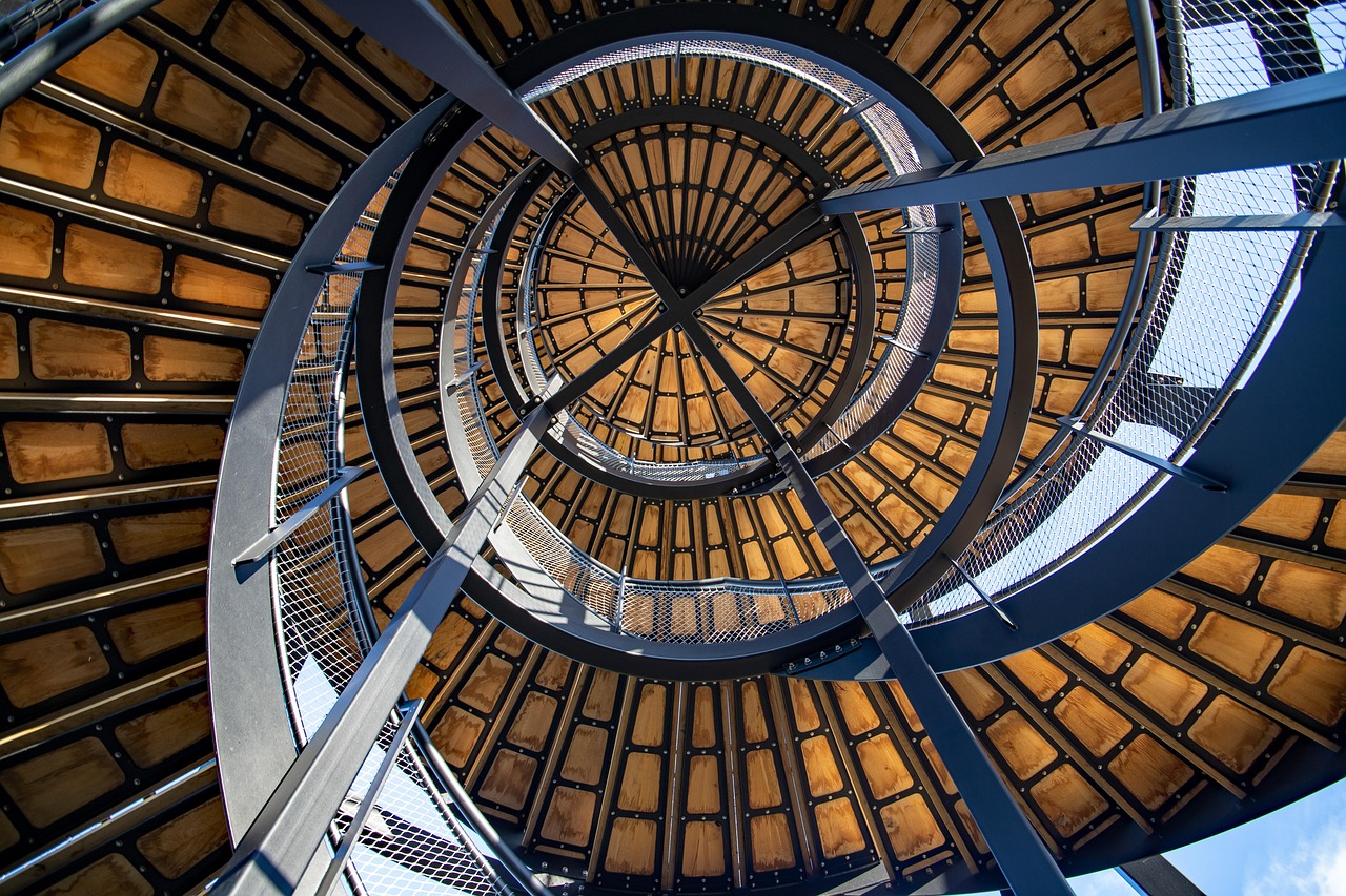 A sculptural spiral staircase with warm wood treads and steel framing